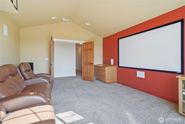 cinema room with lofted ceiling, carpet, and baseboards