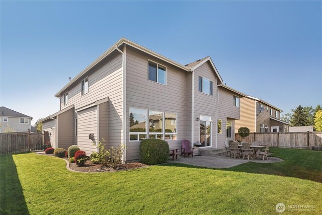 rear view of house with a yard, a fenced backyard, and a patio area