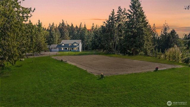 view of yard with driveway, fence, a garage, and an enclosed area