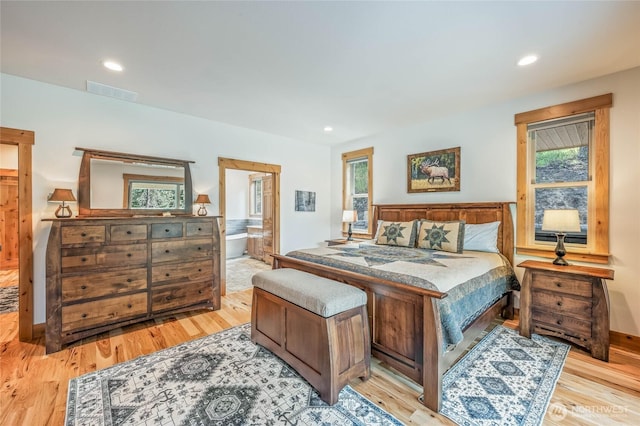 bedroom with visible vents, wood finished floors, baseboards, ensuite bathroom, and recessed lighting