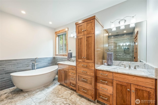 full bath with vanity, recessed lighting, tile walls, a soaking tub, and a stall shower