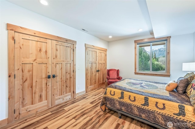 bedroom with recessed lighting, visible vents, and light wood finished floors