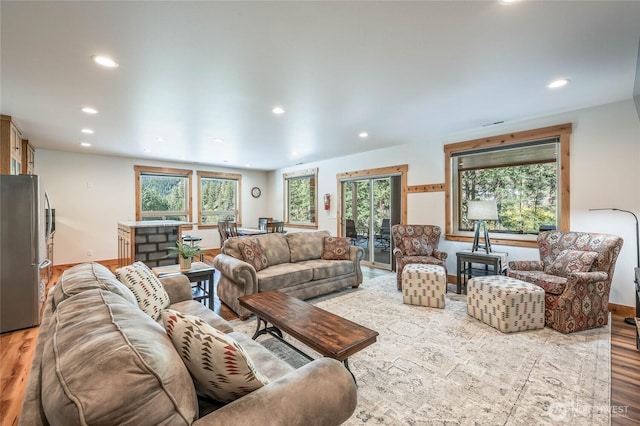 living room with recessed lighting, wood finished floors, and a wealth of natural light