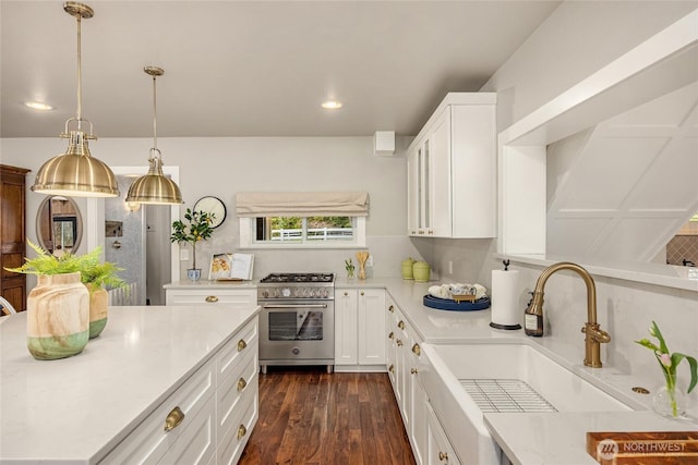 kitchen featuring white cabinetry, a sink, high end range, light countertops, and dark wood finished floors