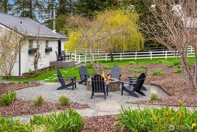 view of yard with a fire pit and fence