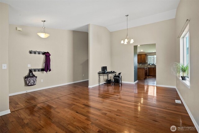 interior space featuring dark wood finished floors, baseboards, and a chandelier