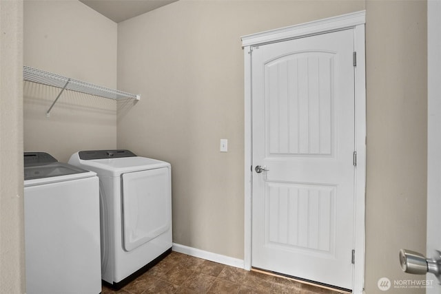 laundry area with baseboards, separate washer and dryer, and laundry area