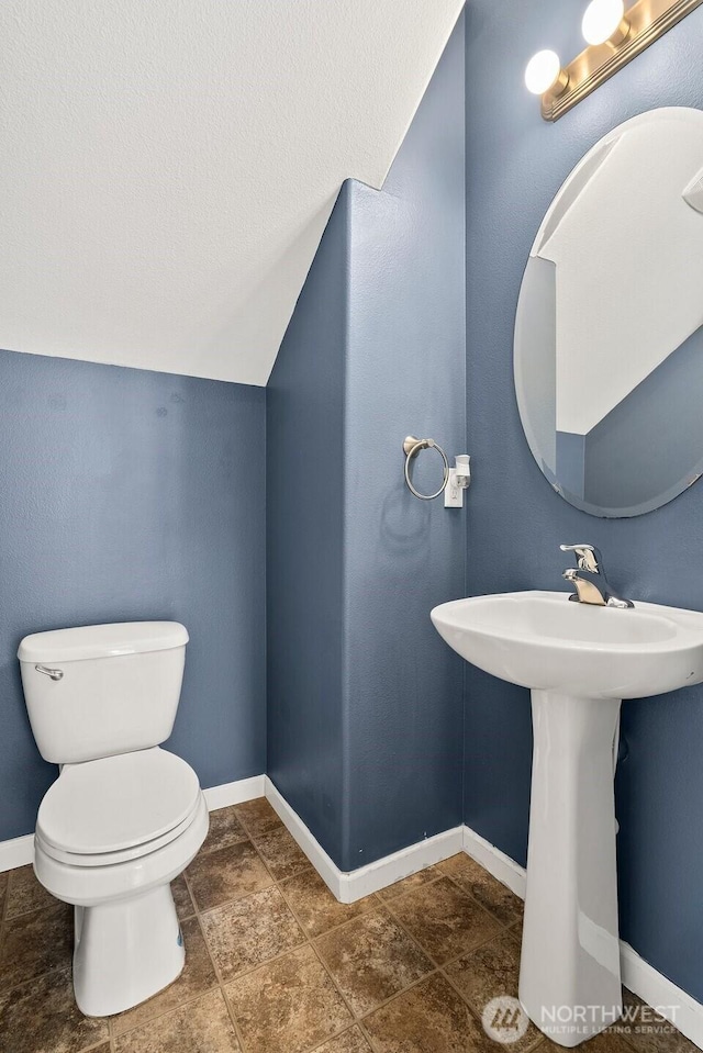 bathroom with toilet and baseboards