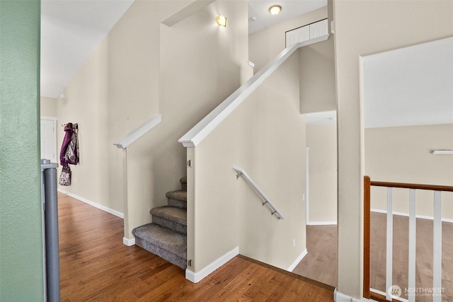 stairs with wood finished floors and baseboards