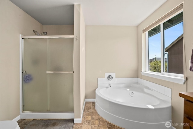 bathroom featuring toilet, a shower stall, a bath, and baseboards