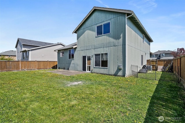 back of house featuring a patio, a fenced backyard, and a lawn