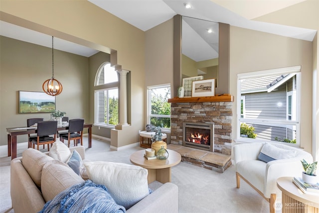 living room featuring light carpet, baseboards, a stone fireplace, a chandelier, and a towering ceiling
