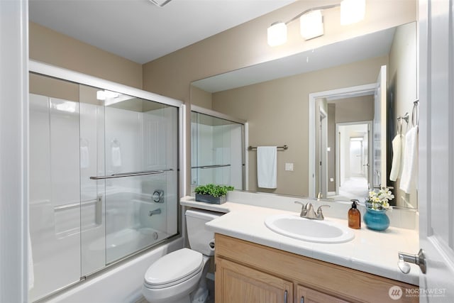 full bath featuring shower / bath combination with glass door, vanity, and toilet