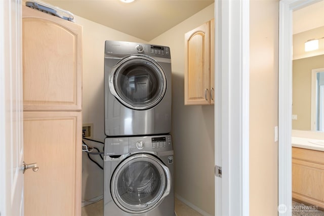 washroom featuring estacked washer and dryer and cabinet space