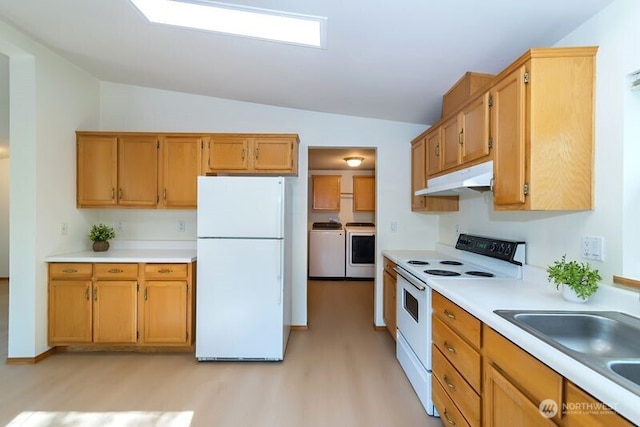 kitchen featuring washer and dryer, white appliances, light wood-style floors, and under cabinet range hood
