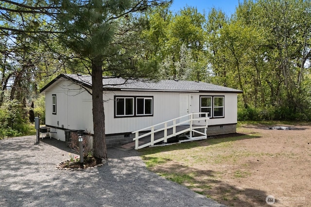 manufactured / mobile home with roof with shingles and crawl space