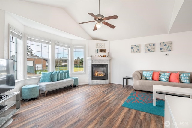 living room with a ceiling fan, a wealth of natural light, wood finished floors, and a glass covered fireplace