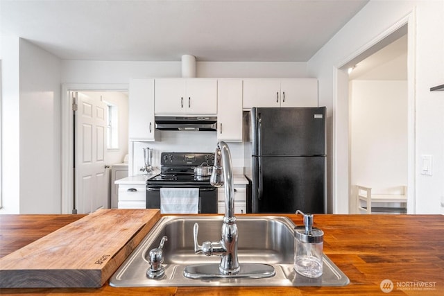 kitchen featuring butcher block counters, under cabinet range hood, black appliances, a sink, and white cabinetry
