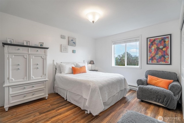 bedroom with dark wood finished floors and a baseboard heating unit