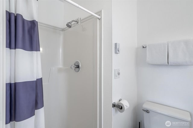 full bathroom with toilet and a shower with curtain