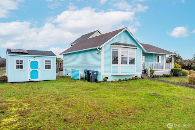 back of property featuring an outdoor structure, a shed, a lawn, and a porch