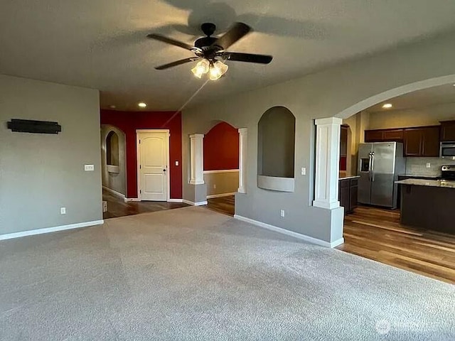 19020 25th Ave E, Tacoma, WA 98445 - unfurnished living room featuring a ceiling fan, baseboards, dark carpet, and arched walkways
