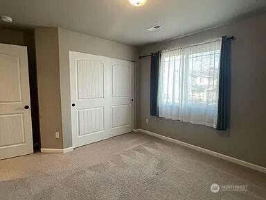 19020 25th Ave E, Tacoma, WA 98445 - unfurnished bedroom with carpet flooring, baseboards, and a closet