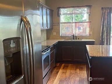 19020 25th Ave E, Tacoma, WA 98445 - kitchen with light wood-style floors, a sink, light stone countertops, and stainless steel appliances