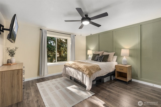 bedroom featuring a ceiling fan, visible vents, a decorative wall, and dark wood finished floors