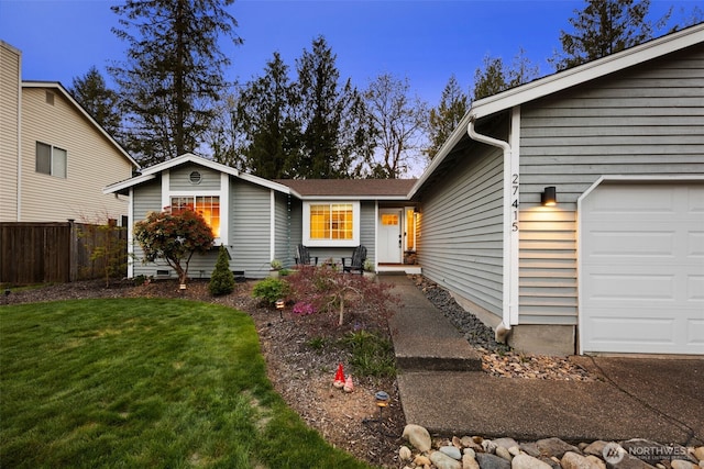 view of front of house featuring an attached garage, a front yard, and fence