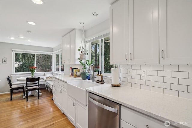 kitchen featuring white cabinets, a sink, dishwasher, recessed lighting, and backsplash