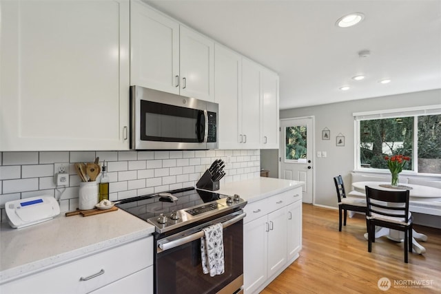 kitchen with appliances with stainless steel finishes, decorative backsplash, white cabinetry, and recessed lighting