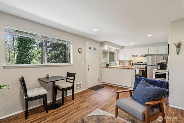 living room with visible vents, dark wood-style flooring, and baseboards