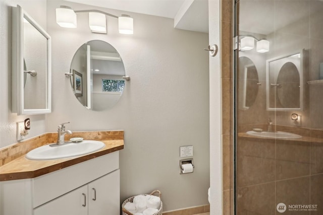bathroom featuring toilet, tiled shower, and vanity