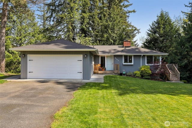 ranch-style home with stairs, aphalt driveway, a chimney, an attached garage, and a front lawn