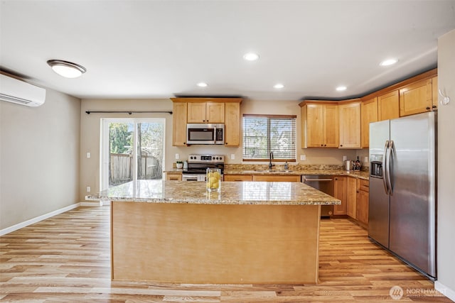 kitchen with stainless steel appliances, a wall mounted AC, a sink, light wood-style floors, and recessed lighting