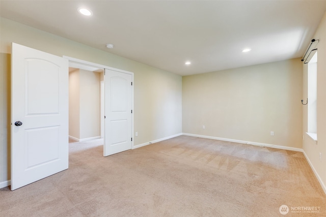 unfurnished room with light colored carpet, recessed lighting, and baseboards