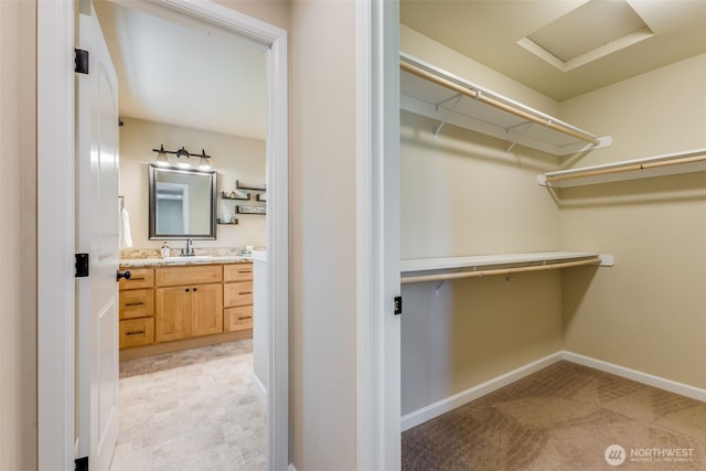 spacious closet with a sink and attic access