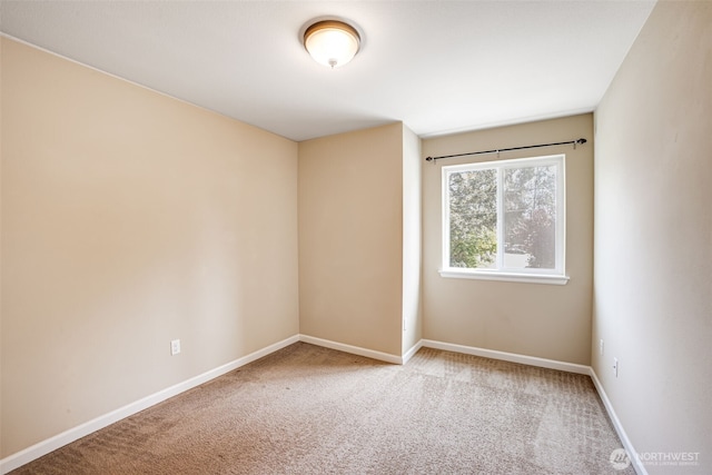 unfurnished room with carpet and baseboards