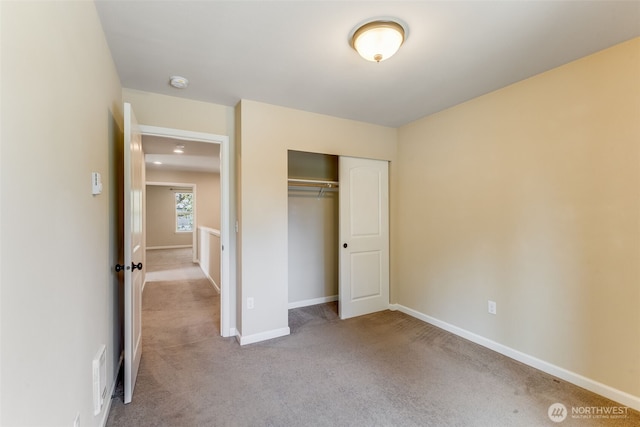 unfurnished bedroom featuring carpet flooring, baseboards, and a closet
