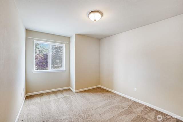 unfurnished room featuring carpet floors and baseboards