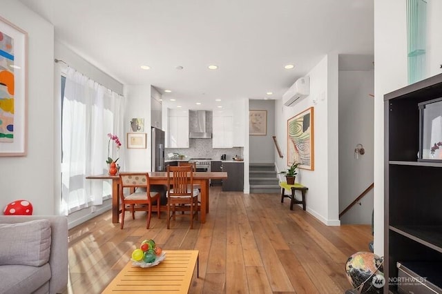 1121 34th Ave Unit A, Seattle, WA 98122 - dining area with a wall mounted air conditioner, stairway, light wood-style flooring, and recessed lighting