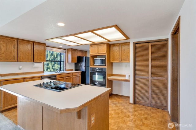 1823 19th Dr, Mukilteo, WA 98275 - kitchen featuring black appliances, light countertops, recessed lighting, brown cabinets, and a breakfast bar area