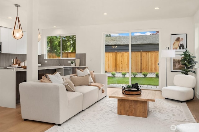 living room with recessed lighting, a healthy amount of sunlight, and light wood finished floors