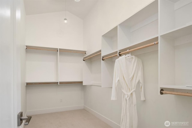 walk in closet featuring carpet flooring and lofted ceiling