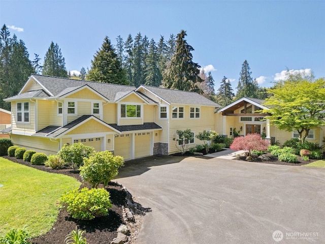 view of front of house with driveway, a front lawn, and an attached garage