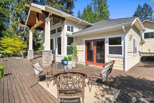 wooden terrace with outdoor dining space and french doors