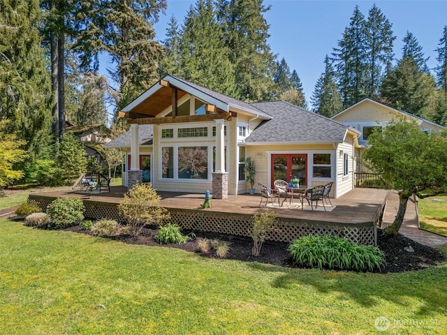 back of property featuring a lawn, a shingled roof, and a wooden deck