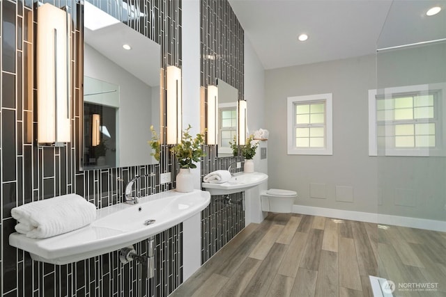 bathroom featuring recessed lighting, toilet, backsplash, baseboards, and wood finished floors