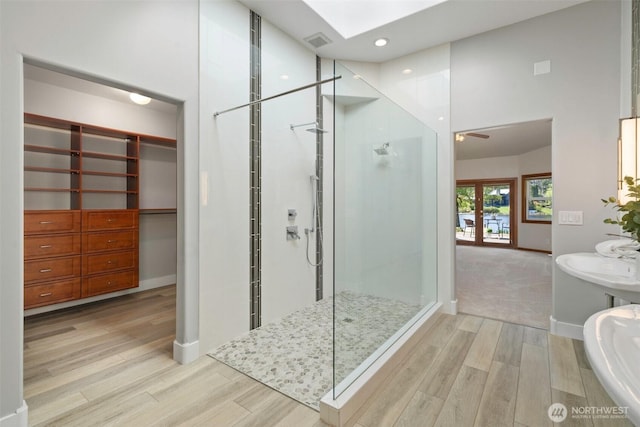 full bathroom with visible vents, wood finished floors, french doors, and a walk in shower